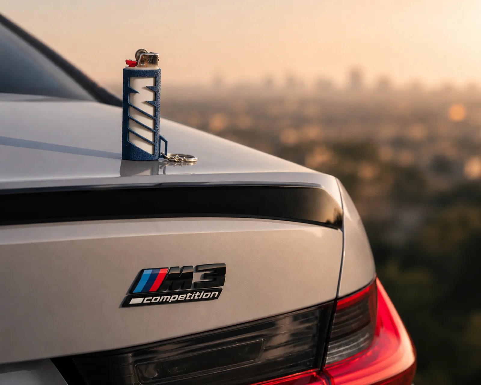 Blue lighter case staged on a BMW M3 trunk at sunset
