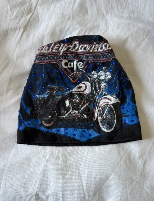 Raw phone photograph of the blue motorcycle DON beanie on fabric