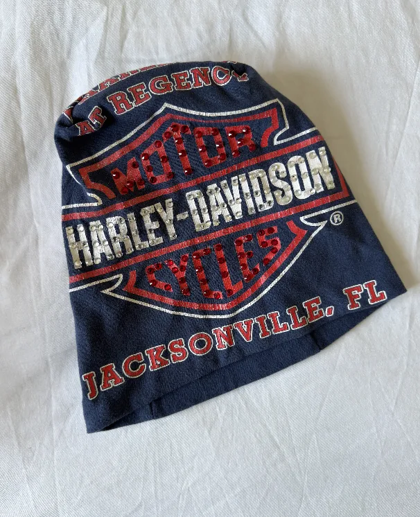 Raw phone photograph of navy Jacksonville Harley-Davidson beanie on fabric